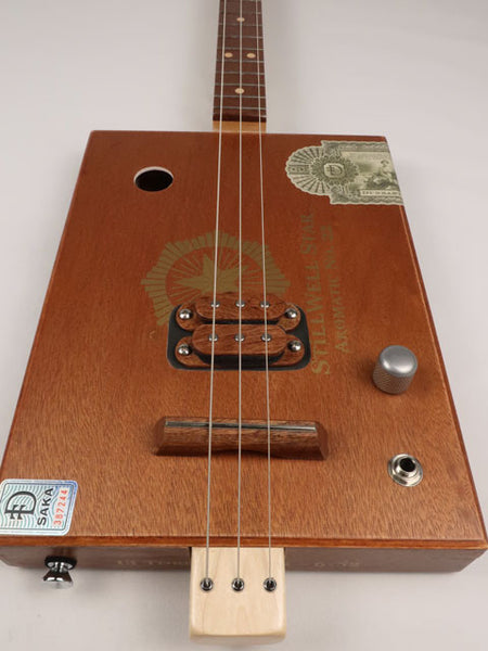 Front view of a 3 string cigar box guitar made with a StillWell Star cigar box. This cigar box guitar is made with a sapele fretboard and maple inlay by Mike Snowden of Snowden Guitars.