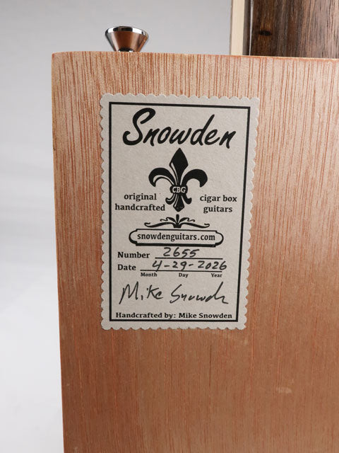 Back view of a cigar box guitar with a Snowden Guitars logo. This sticker shows the date and number made by Mike Snowden of Snowden Guitars.