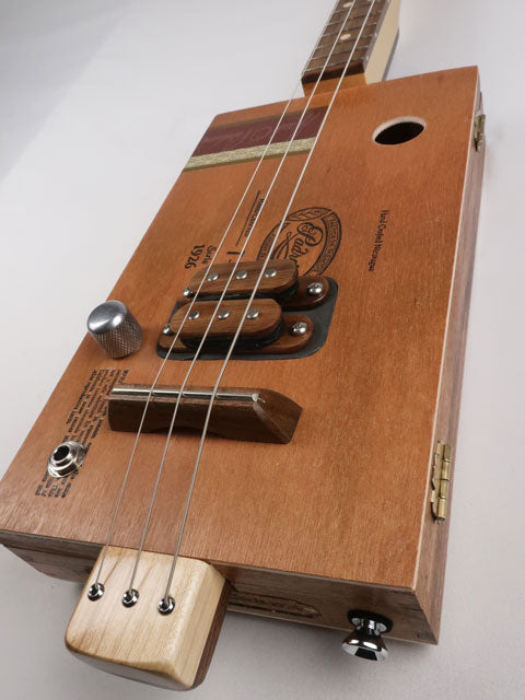 Front view of a 3 string cigar box guitar made with a Padron cigar box. This cigar box guitar is made with a walnut humbucker pickup and walnut fretboard. Handmade by Mike Snowden of Snowden guitars.