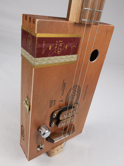 Front view of a 3 string cigar box guitar made with a Padron cigar box. This cigar box guitar is made with a walnut humbucker pickup and walnut fretboard. Handmade by Mike Snowden of Snowden guitars.