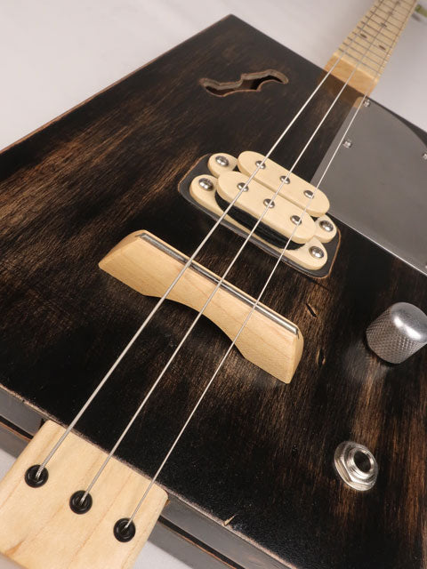 Front tilted view of a 3 string cigar box guitar with a humbucker pickup. Handmade by Mike Snowden of Snowden Guitars.