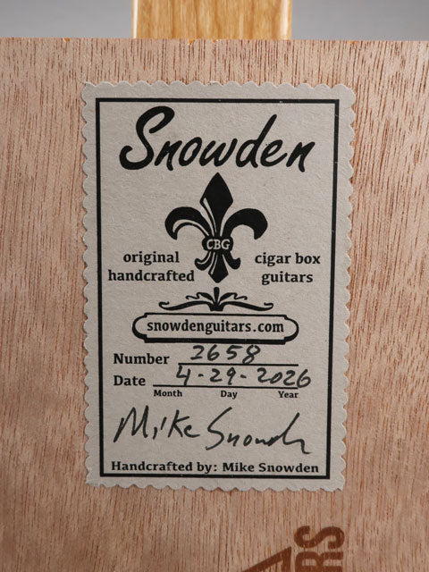 Back view of a Snowden Guitars logo sticker on a cigar box guitar. This sticker shows the date and number of cigar box guitars made as of this date.