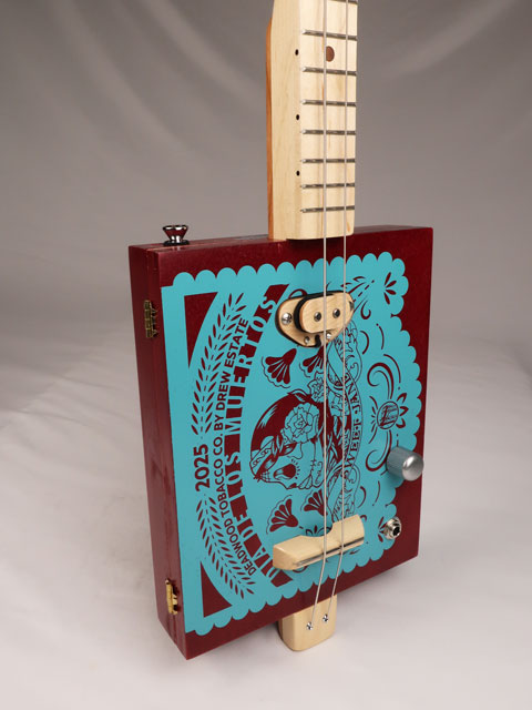 Tilted front view of a 2 string cigar box guitar made with a Sweet Jane cigar box. Handmade by Mike Snowden of Snowden Guitars.