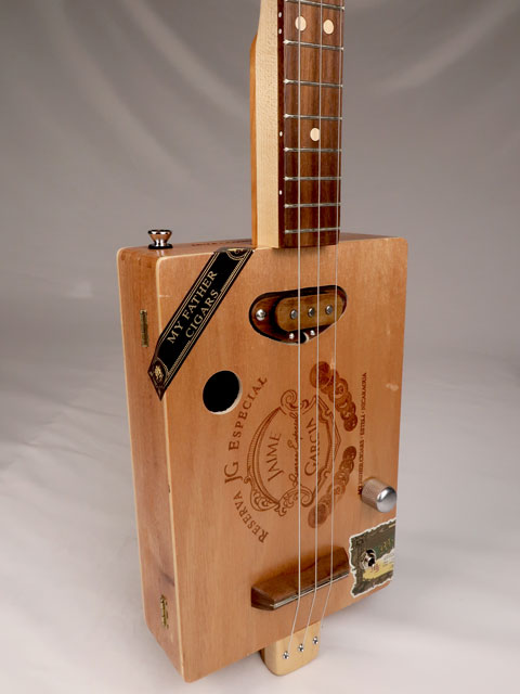 Front view of a 3 string cigar box guitar made with a Jaime Garcia cigar box. Handmade by Mike Snowden of Snowden Guitars.