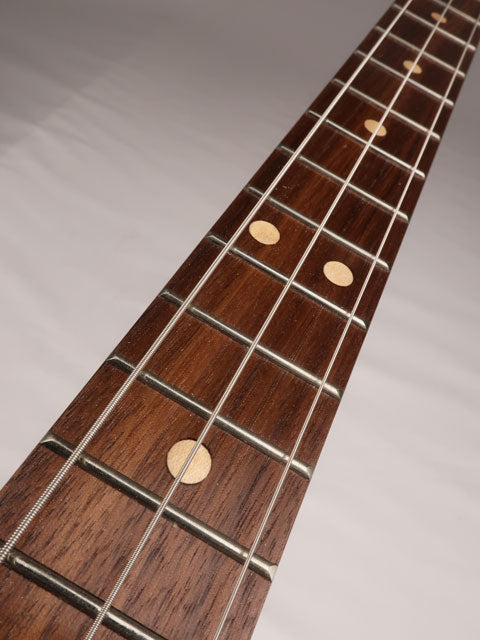 Front view of a 3 string cigar box guitar with a walnut fretboard and maple inlay. Handmade by Mike Snowden of Snowden Guitars.