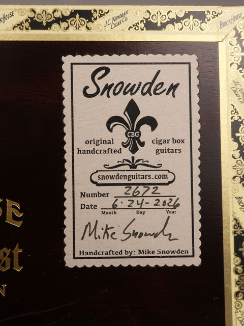 Back view of a cigar box guitar label made by Mike SnowdenGuitars. The tag shows the date and number of guitars made by Mike Snowden of Snowden Guitars.