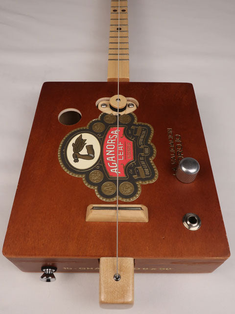 Front view of a single string diddly bow cigar box guitar made with a Aganorsa Leaf cigar box. Handmade by Mike Snowden of Snowden Guitars.