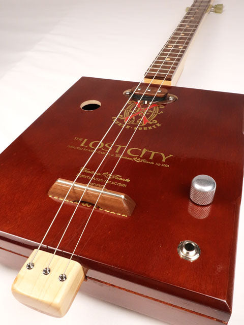 Front tilted view of a 3 string cigar box guitar made with a Lost City Cigar box. Handmade by Mike Snowden of Snowden Guitars.