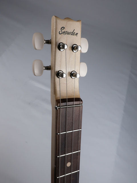 Close-up front view of a cigar box guitar headstock with a Snowden Guitars logo at the top. This cigar box guitar has a maple neck and a walnut fretboard and is handmade by Mike Snowden.