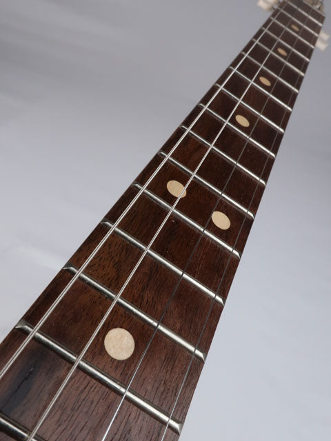 Front view of a cigar box guitar walnut fretboard with maple inlay. This 4 string cigar box guitar is handmade by Mike Snowden.