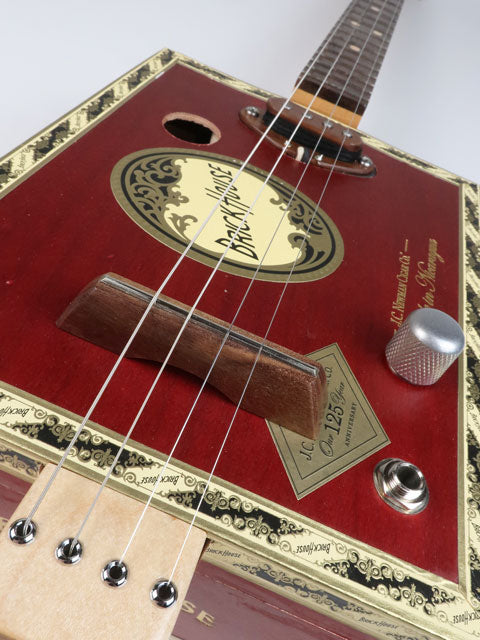 Tiled front view of a 4 string cigar box guitar made with a Brick House cigar box and a walnut single coil pickup. This red cigar box guitar is handmade by Mike Snowden.