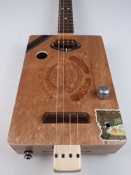 Front view of a Cigar Box Guitar handmade by Mike Snowden. This cigar box guitar is made from a Jaime Garcia cigar box with a walnut single coil pickup.