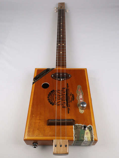 Front view of a 3 string Cigar Box Guitar made with a walnut single coil pickup. This cigar box guitar was handmade by Mike Snowden of Snowden Guitars.