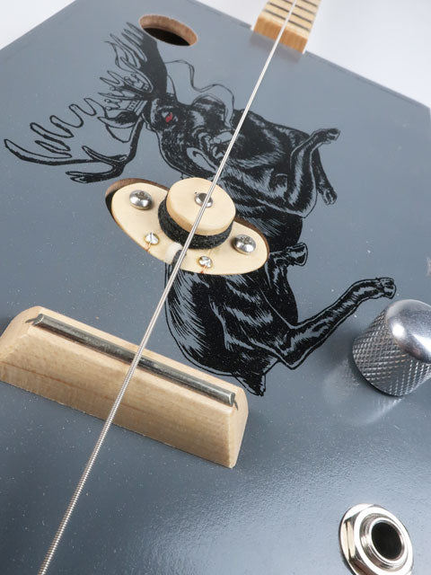 Close up view of a one string cigar box guitar and its maple single coil pickup handmade by Mike Snowden.
