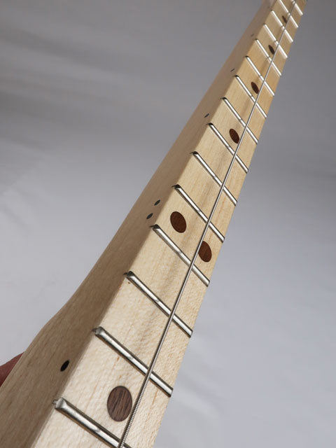 Close-up side view of a one string cigar box guitar neck made from maple with walnut inlay. This cigar box guitar is made by Mike Snowden.
