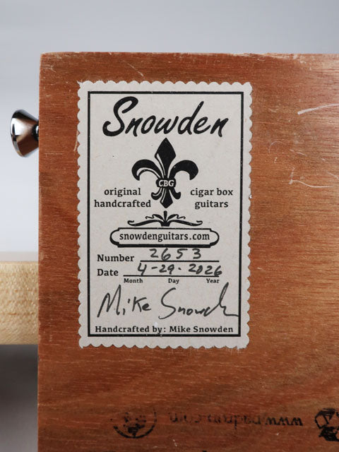 Close-up back view of a cigar box guitar logo stick with the builder's logo.. This cigar box guitar is made by Mike Snowden of Snowden guitars.