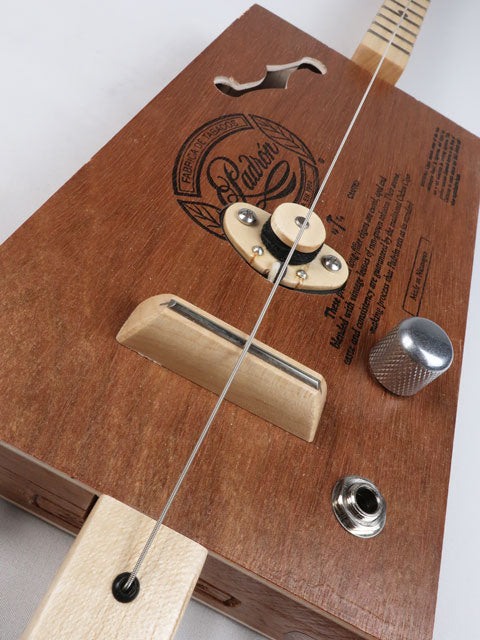 Tiled front view of a one string diddly bow cigar box guitar with a maple single coil pickup and a maple neck and frets. This cigar box guitar is handmade by Mike Snowden.