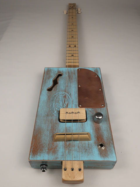 Blue cigar box guitar front view with p90 pick and copper pick guard made by Mike Snowden. 