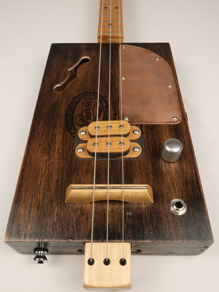 Wooden cigar box guitar with humbucker and copper pick guard front view. Made by Mike Snowden with a Padron cigar box.