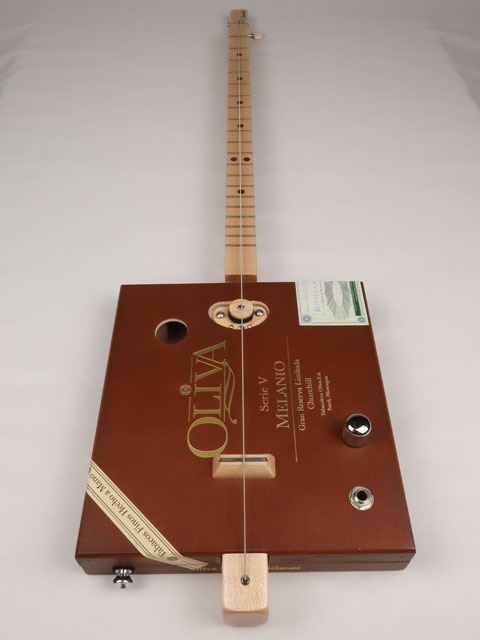 Front view of a one string cigar box guitar diddly bow cbg made with an Oliva cigar box. This cigar box guitar is handmade by Mike Snowden of Snowden Guitars.