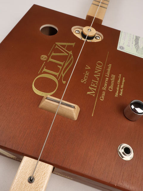 Front view of a one string cigar box guitar diddly bow cbg made with an Oliva cigar box. This cigar box guitar is handmade by Mike Snowden of Snowden Guitars.