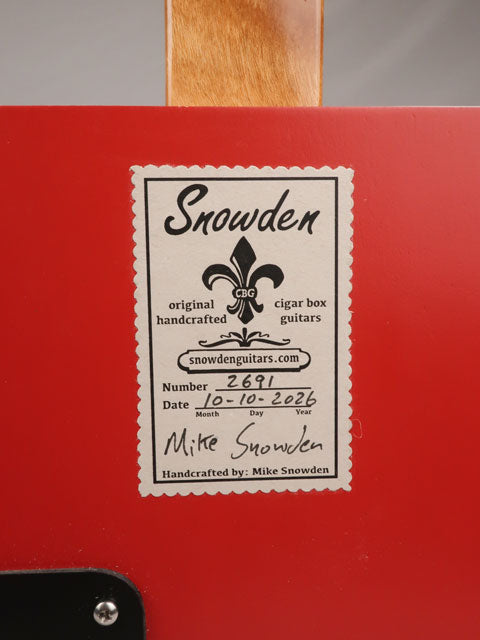 Back view of a cigar box guitar handmade by Mike Snowden of Snowden Guitars. The back of the cigar box has a tag with the date and number of cigar box guitars made.