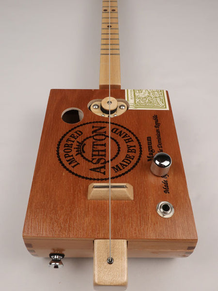 Front view of a Cigar Box Guitar diddly bow one string handmade by Mike Snowden. This cigar box guitar is made with an Ashton cigar box by Mike Snowden of Snowden Guitars.