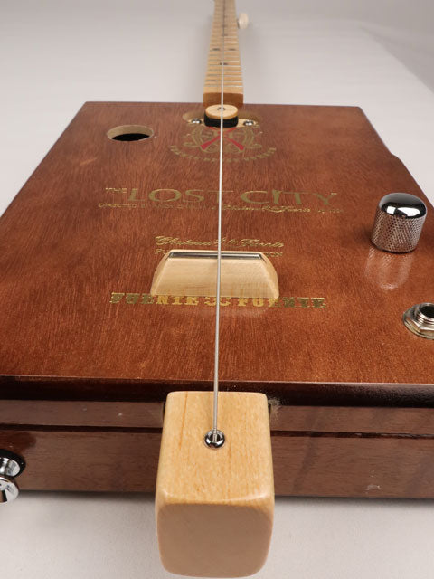 Front tilted angle view of a one String diddly bow cigar box guitar CBG handmade by Mike Snowden of Snowden Guitars. This cigar box guitar is handmade with a Lost City cigar box.