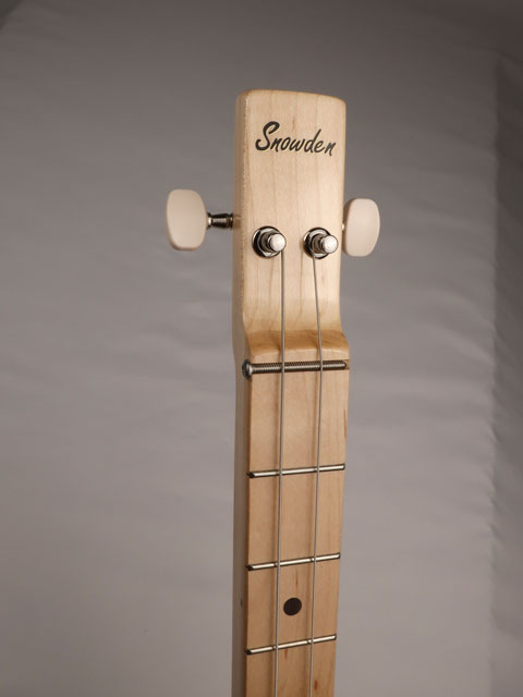 Front view of a cigar box guitar headstock with a Snowden Guitars logo on the front.