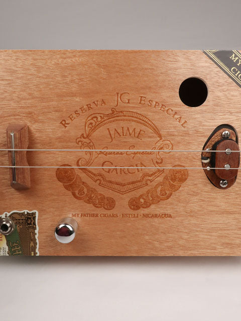 Front view of a cigar box guitar with a Jaime Garcia cigar box. This cigar box guitar is handmade by Mike Snowden of Snowden Guitars.